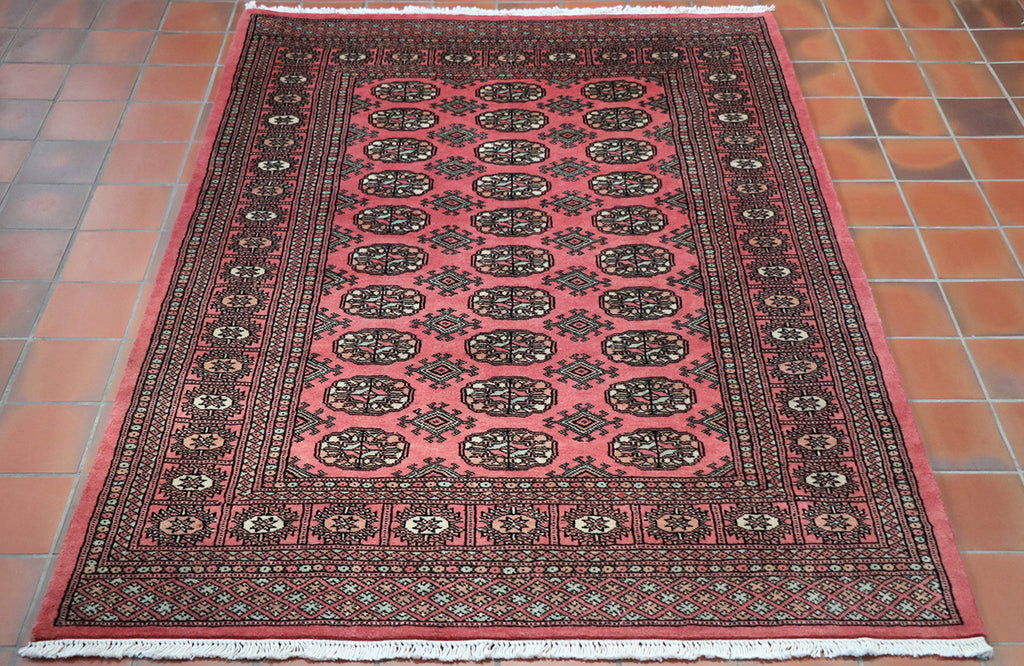 Deep rose colour throughout the piece.  The decoration has been carried out in black with a broad border with intricate design using peach, soft green and cream.  The central section has  30  decoratif motifs laid out in three rows of 10 symmetrically down the length of the piece. 