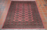 Deep rose colour throughout the piece.  The decoration has been carried out in black with a broad border with intricate design using peach, soft green and cream.  The central section has  30  decoratif motifs laid out in three rows of 10 symmetrically down the length of the piece. 