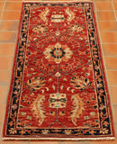 There is a warm terracotta red ground on this piece, with a deep blue border.  Bold golden yellows are used in the decorative floral motifs, with interlocking leaf decoration. 
