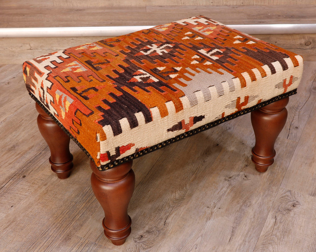 Theses Turkish Kilim stools often uses salvaged pieces.  This use produces an interesting look with the pattern being offset rather than centred, making the pieces unique and different.  This has an Autumnal mix of colours, very earthy tones consisting of dark brown, different shades of orange, mushroom and ivory. The design is geometric shapes, almost snowflake like but also with some interlocking medallions.  