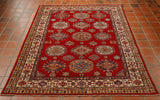 Bright red central section with medallions upon it laid out symmetrically.  There are several borders of differing widths and patterns.  The colour used in the decoration consists of blues, greens, golden yellow, and an ivory cream. 