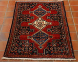 Central red shaped section on a dark blue background.  There are 3 medallions upon the central section.  Throughout there is floral decoration using a colour palette of blues, reds, creams and highlights in green. 